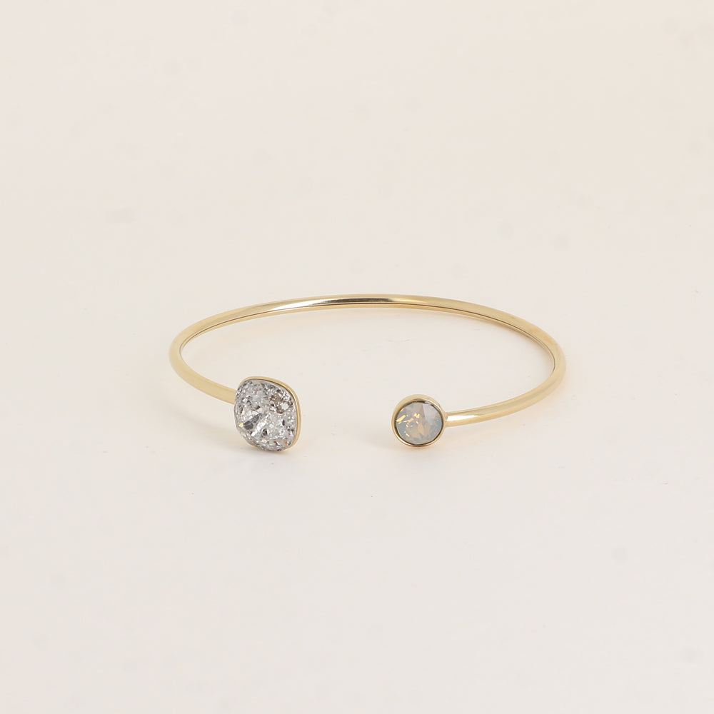 Jonc orné de cristaux de Swarovski® 10 mm et SS29 - Hauteur du jonc: 11 mm - Dimension du cristal 1: 10x10 mm - Diamètre du cristal 2: 7 mm - Silver patina et light grey opal