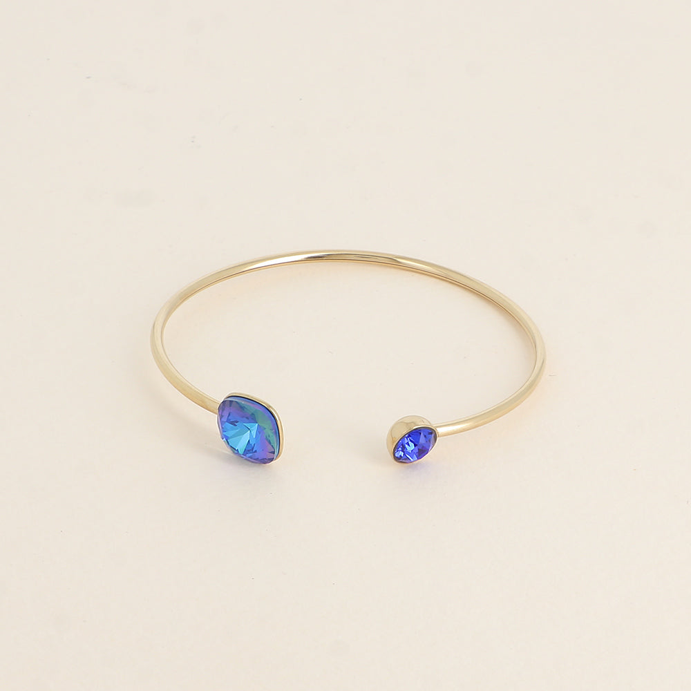 Jonc orné de cristaux de Swarovski® 10 mm et SS29 - Hauteur du jonc: 11 mm - Dimension du cristal 1: 10x10 mm - Diamètre du cristal 2: 7 mm - Royal blue delite et majestic blue