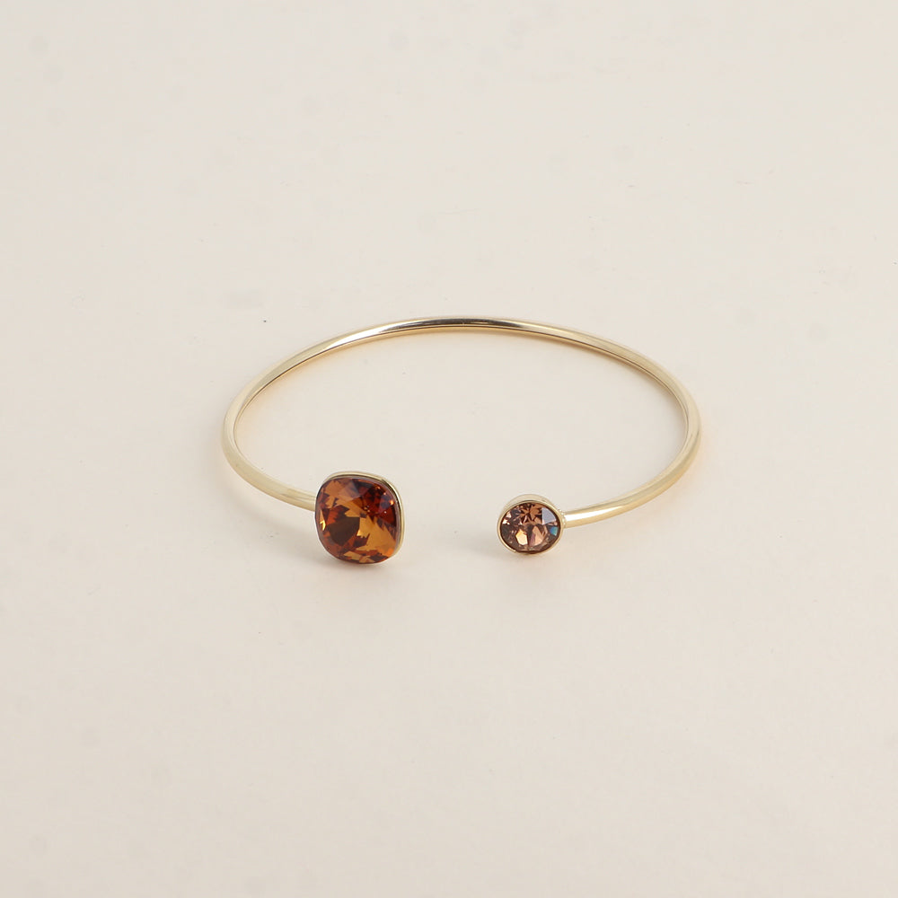 Jonc orné de cristaux de Swarovski® 10 mm et SS29 - Hauteur du jonc: 11 mm - Dimension du cristal 1: 10x10 mm - Diamètre du cristal 2: 7 mm - Light amber et light smoked topaz