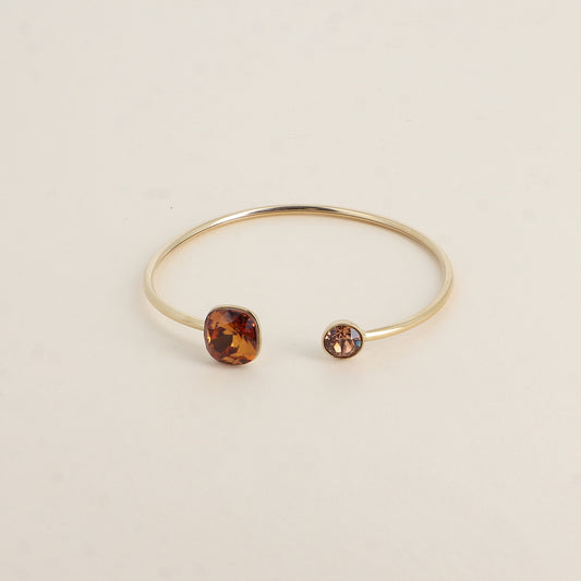 Jonc orné de cristaux de Swarovski® 10 mm et SS29 - Hauteur du jonc: 11 mm - Dimension du cristal 1: 10x10 mm - Diamètre du cristal 2: 7 mm - Light amber et light smoked topaz
