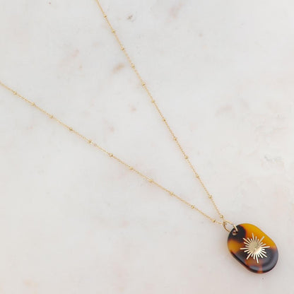 Collier doré composé d'un pendentif en acétate marron léopard orné d'un soleil 65+5 cm